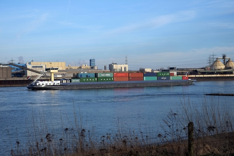 Container Schiff das den Rhein hinauffährt, mit Waren aus China. Auf den Containern steht zum Beispiel China Shipping. Auch Kohle für unsere Kohlekraftwerke wird auf Schiffen den Rhein hinauftransportiert. Da kommt Kohle aus Kolumbien übers Meer, wird den Rhein rauftransportiert und dann verbrannt. rheinschiff_container.jpg