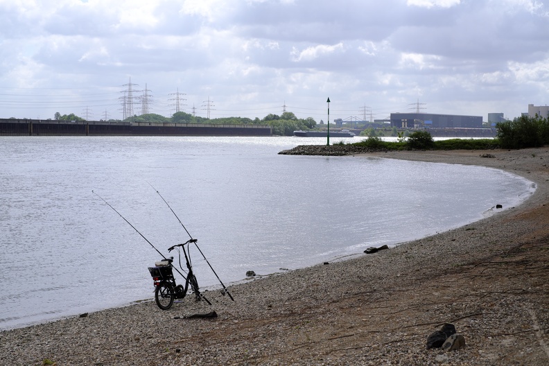 Der Angler ist mit dem Minirad angereist. Er sitzt außerhalb des Fotos und spielt mit seinem Smartphone. angler_minirad.jpg